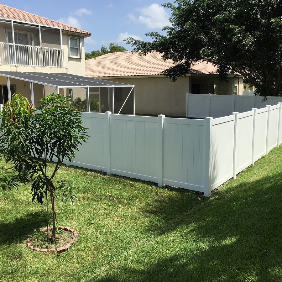 residential fence installation of a white pvc fence